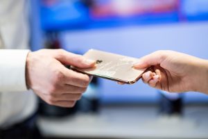 Kunde übergibt defektes Smartphone zur Reparatur an Alptel Spezialist