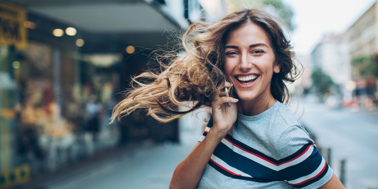 Junge Frau telefoniert lachend mit dem perfekten Mobile-Abo